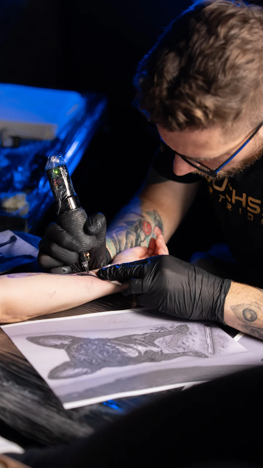 Damian Kwiatkowski podczas tatuowania przedramienia w studiu DK Tatuaż Bydgoszcz.